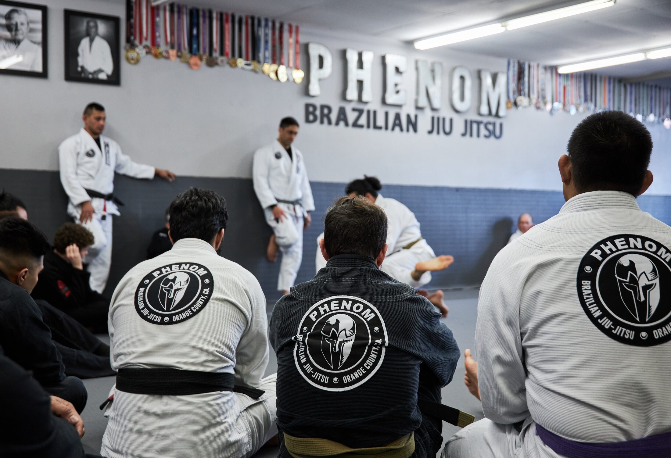 Adults drilling guard technique in a Brazilian Jiu-Jitsu fundamentals class at Phenom BJJ