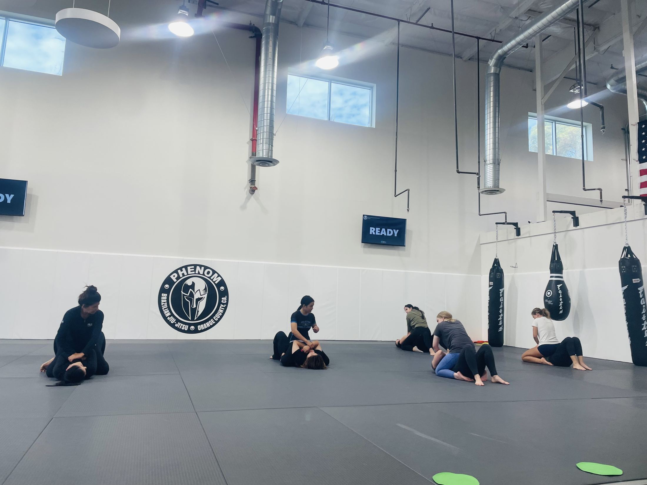 Women drilling Brazilian Jiu-Jitsu positions in pairs during the Sunday beginner class at Phenom BJJ